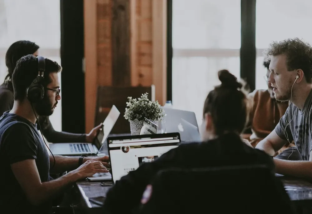 A team working on laptops at a shared table