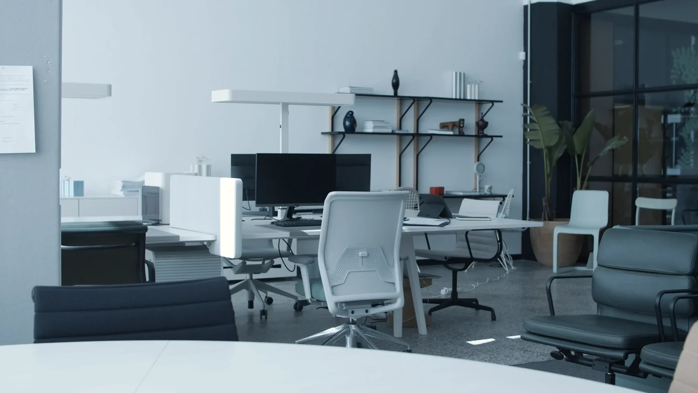 An open-plan office with desks, monitors and chairs